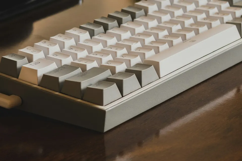 A keyboard on a wooden desk in evening light