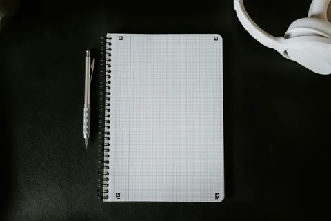 A grid notebook and pen laid out for a monthly review
