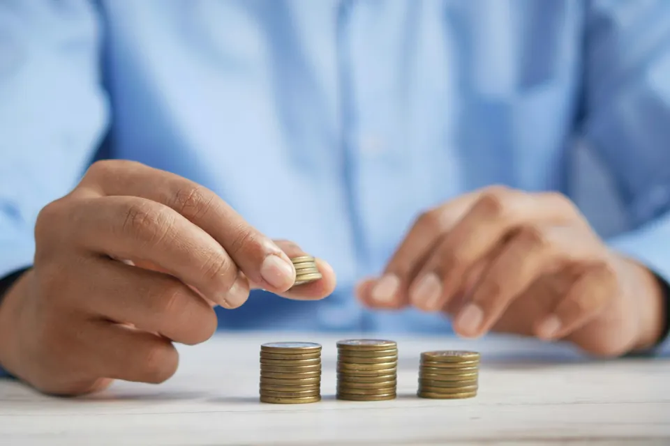 Coins stacked one at a time on a table